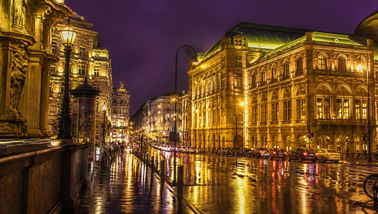 Illuminated historic boulevard in Vienna at night with wet asphalt reflections